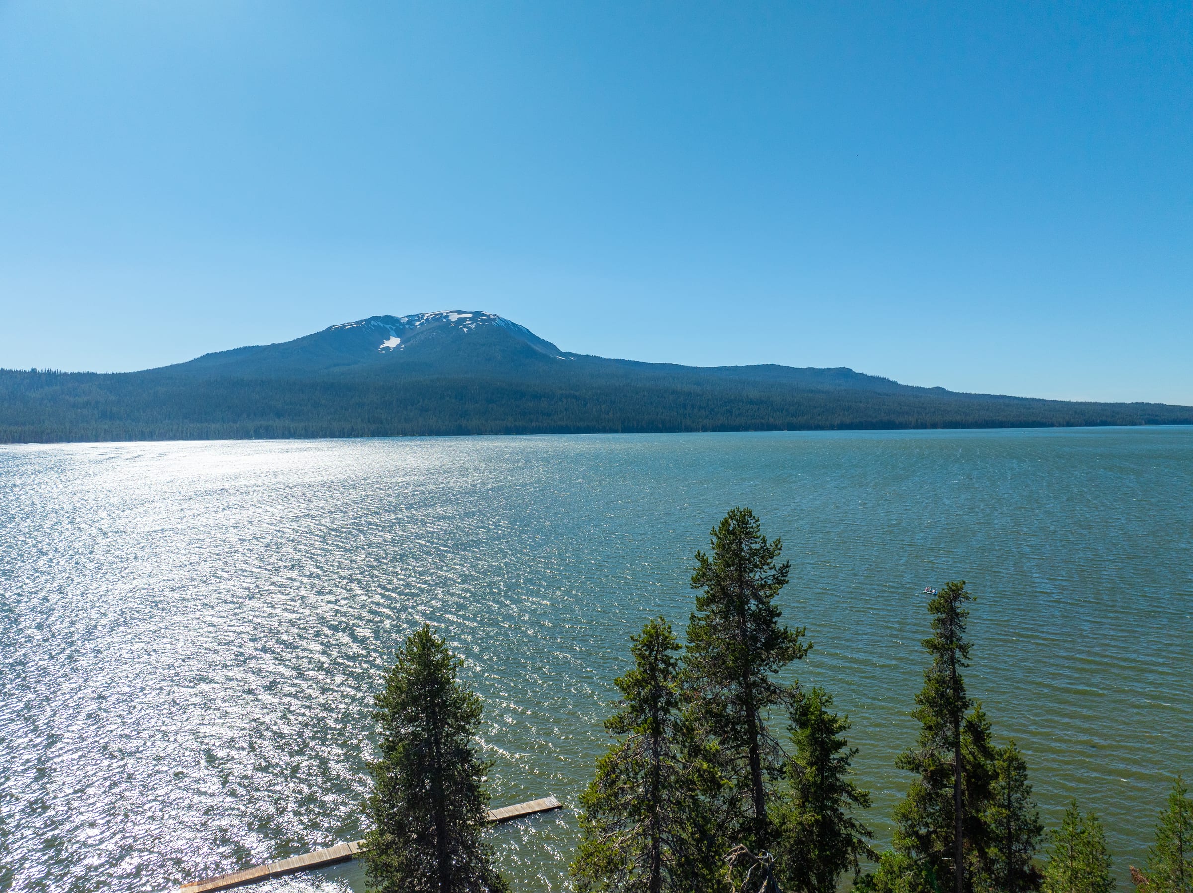 Mount Bailey above the bright water of Diamond Lake in July, firs and a dock in the foreground