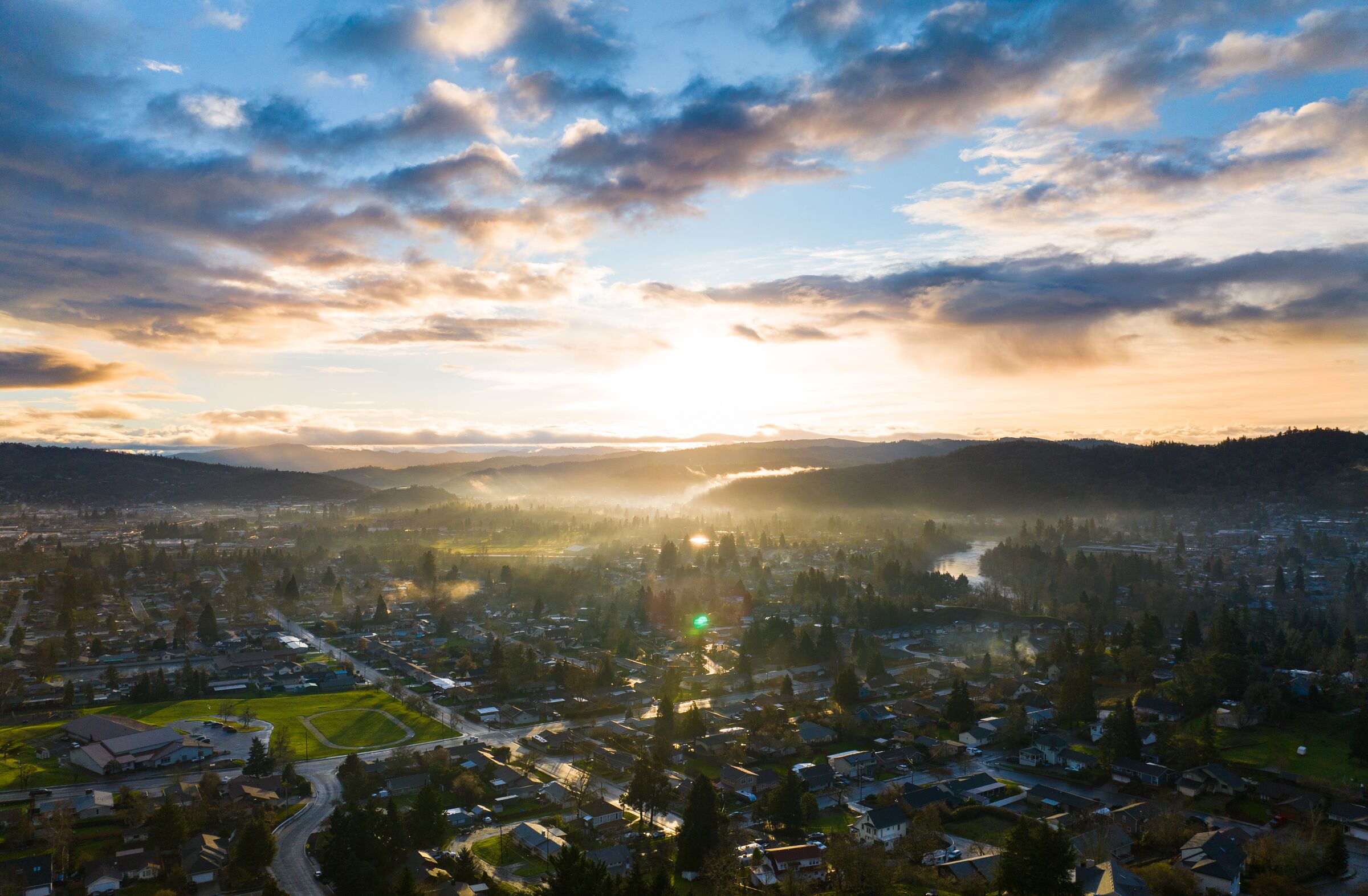 Sunrise over Roseburg in January, low cloud over the valley and the town's rooftops among the trees