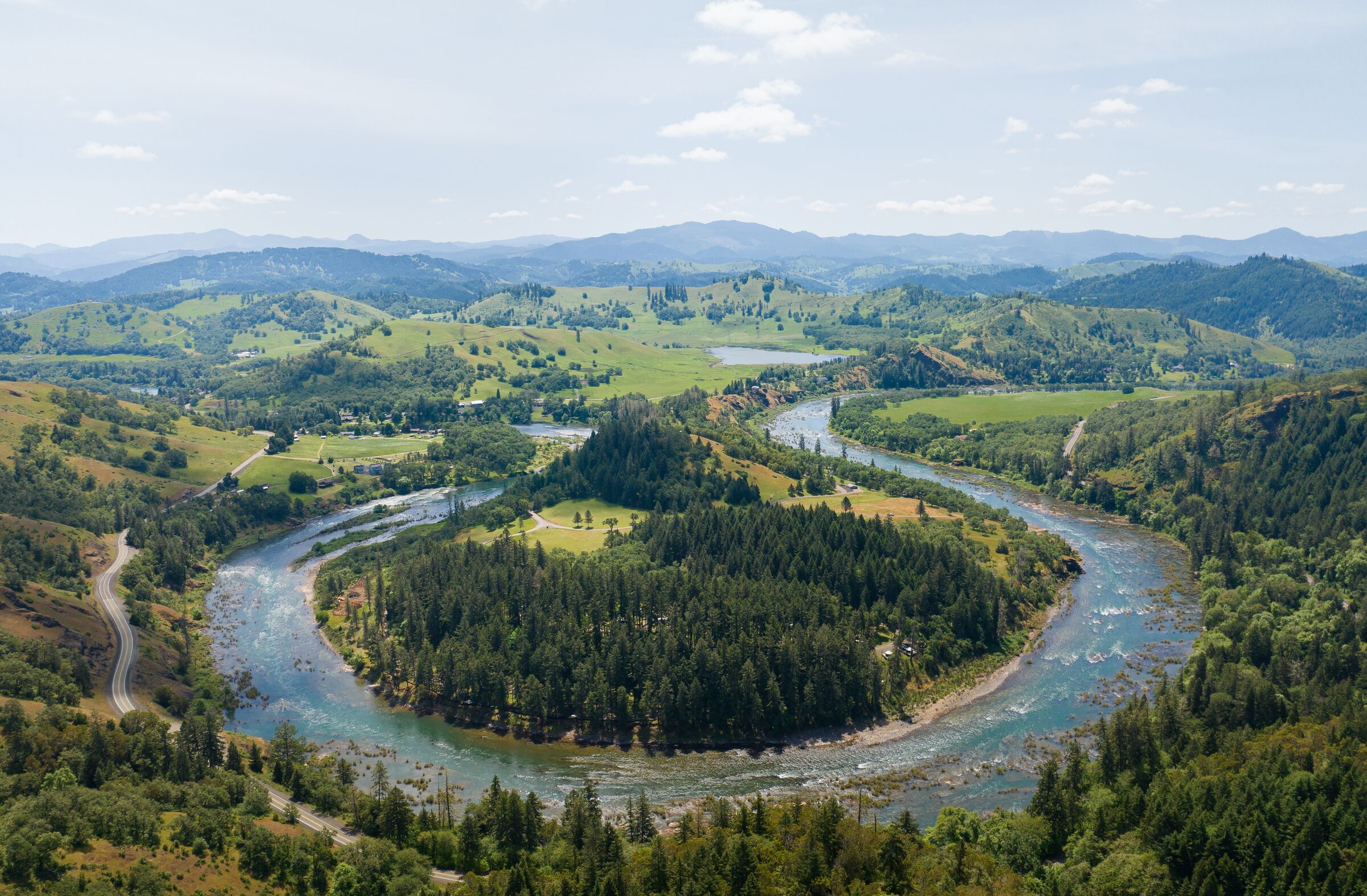 The North Umpqua River making a horseshoe loop around a wooded point at Whistlers Bend in May, seen from the air